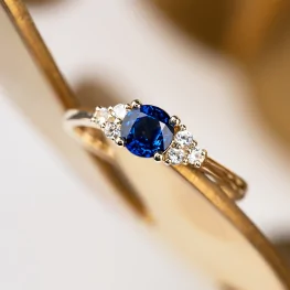 Złoty pierścionek z niebieskim szafirem i diamentami TP0067ZNSR