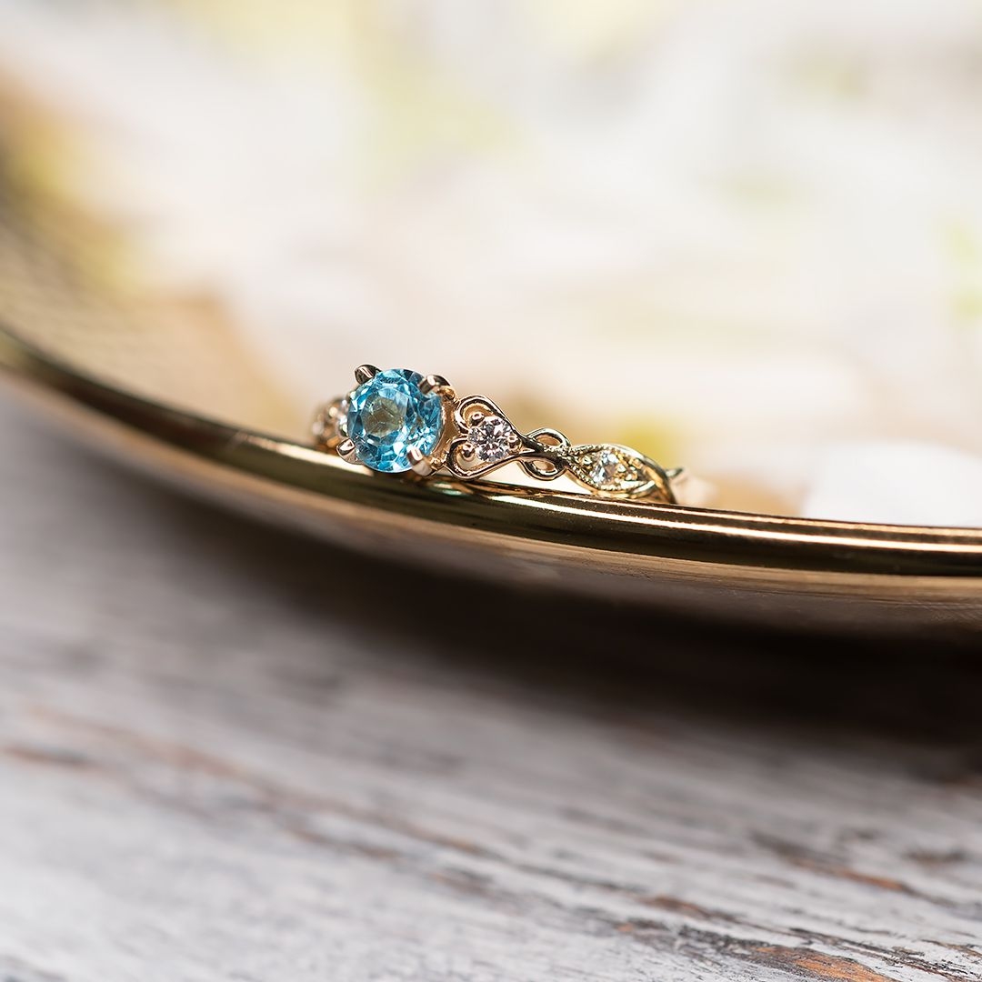 Złoty pierścionek z niebieskim topazem i diamentami
