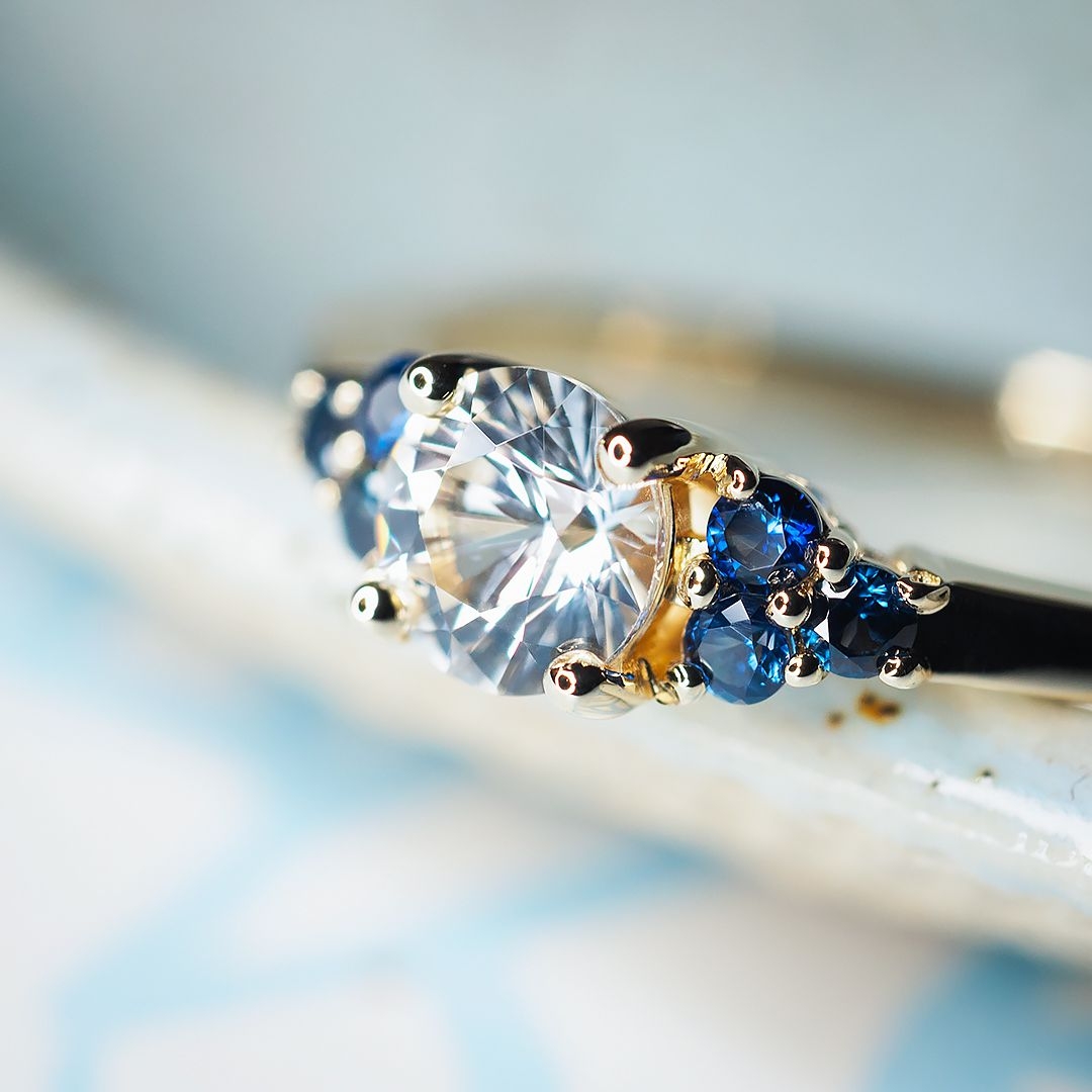 Złoty pierścionek z białym i niebieskim szafirem
